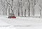 Truck with snowplow clearing road during snowstorm