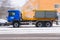 Truck spreading road salt on the icy and snowy road