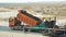 Truck throws black asphalt gravel pile into special machine