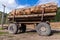 Truck trailer full of thick cedar logs. Side view