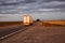 A truck with a trailer transports cargo in the summer against the backdrop of sunset and beautiful evening nature. The