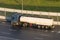 Truck with a trailer white tank on the highway in the sunset light.