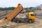 Truck unloads sand on the construction site