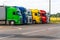 Trucks with containers in the parking lot along the highway against the background of clouds. The concept of logistics, transport