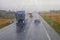 trucks drive along the main slippery road during the rain. Bad weather.