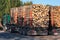 Trucks loaded with tree trunks along the roadside in front of a