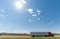 Trucks passing, mesa landforms on horizon beyond Landscape along