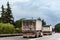 Trucks with tarpaulin tippers for bulk transport driving on a highway, rear view