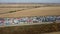 Trucks with trailers stand in a long queue at the port terminal for unloading grain.