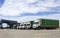 Trucks transport poultry food under the blue sky at day.