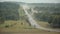 Trucks traveling on a road between forests.