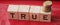 True word on wooden cubes on red. True or false facts, real and fake news concept