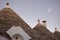 Trulli with moon at sunset in Alberobello (Italy)