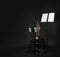 Trumpet, chair and note stand with music sheets on black. Space for text