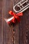 Trumpet with red ribbon on wooden background.
