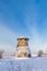 Truncated windmill, a house and snow