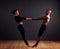 Trust and collaboration. A female and male contemporary dancer performing a dramatic pose in front of a dark background.