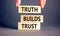 Truth builds trust symbol. Concept words Truth builds trust on wooden blocks on a beautiful grey table grey background.