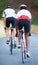 Trying to pass the leader. Rearview shot of two riders cycling down a rural road together.