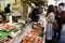 Tsukiji, Tokyo, Japan - June 30, 2022 : Japanese fishmonger sell fresh slicing sashimi yellow fin tuna meat to customer at seafood