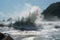 tsunami waves pounding into shore, sending spray and debris flying