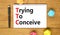 TTC trying to conceive symbol. Concept words TTC trying to conceive on white note on a beautiful wooden table wooden background.