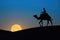 Tuareg riding a camel in desert at night with full supermoon in the background. Generative Ai