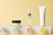 Tube, bottle and jar skincare product mockup standing on geometrical abstract podium on pastel yellow