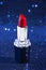 Tube of Classic Bright Red Lipstick on a Blue Glittery Background