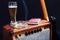 Tube combo amplifier for guitar with black electric guitar, glass of beer and smoking cigarette on black background