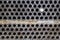 Tube sheet plate of heat exchanger or boiler closeup texture macro background with disconnected muted clogged leaky tube with