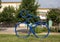 Tubular steel sculpture of a person riding a bike in the grass near the historic Vandergriff Office Building in Arlington, Texas.