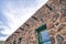 Tucson, Arizona- Stone house with vigas and green window frame