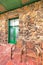 Tucson, Arizona- Wooden armchairs near the rock wall and front green double door with transom window