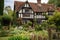 tudor house surrounded by greenery and flowers