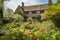 tudor house, surrounded by picturesque garden, with blooming flowers and shrubbery