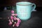 Tuesday coffee concept with text greeting on a cup of morning coffee or tea written - HELLO TUESDAY, and little pink roses flower