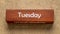 Tuesday and Wednesday text on wooden block against handmade bark paper