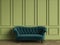 Tufted emerald green sofa in classic interior with copy space