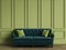 Tufted emerald green sofa in classic interior with copy space