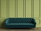 Tufted emerald green sofa in classic interior with copy space