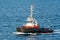 The tug AROS navigates on the sea to assist a cruise ship entering the port