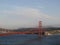 Tug boat sails under Golden Gate Bridge with San Francisco Cityscape