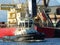 Tug vessel entering port, bulk cargo ship on the background.