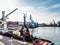 Tugboat assist on a pier in the harbor, cargo sea port over the sea, Floating cargo crane, Granary elevators, harbor, boats and