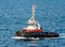 A tugboat with a Danish flag navigates on the sea