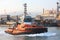 Tugboat passes through the calm channel of the port of Genoa