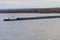 Tugboat pushing a heavy long barge on river Dnieper