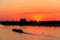 Tugboat pushing heavy long barge on the river Dnieper at sunset