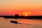 Tugboat pushing heavy long barge on the river Dnieper at sunset